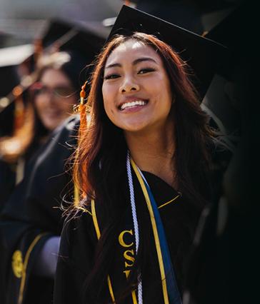 A young woman smiles at Commencement