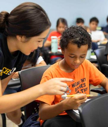 Child completes a nutrition worksheet at a desk