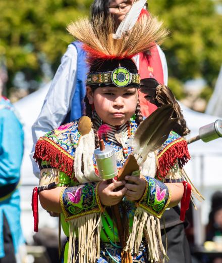 Young boy wearing Native American regalia 