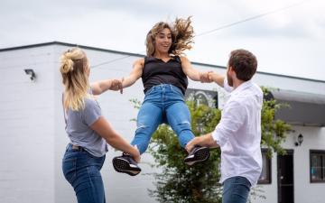 Bossy Flyer photo. One dancer is swung into the air by two other dancers on either side of her.