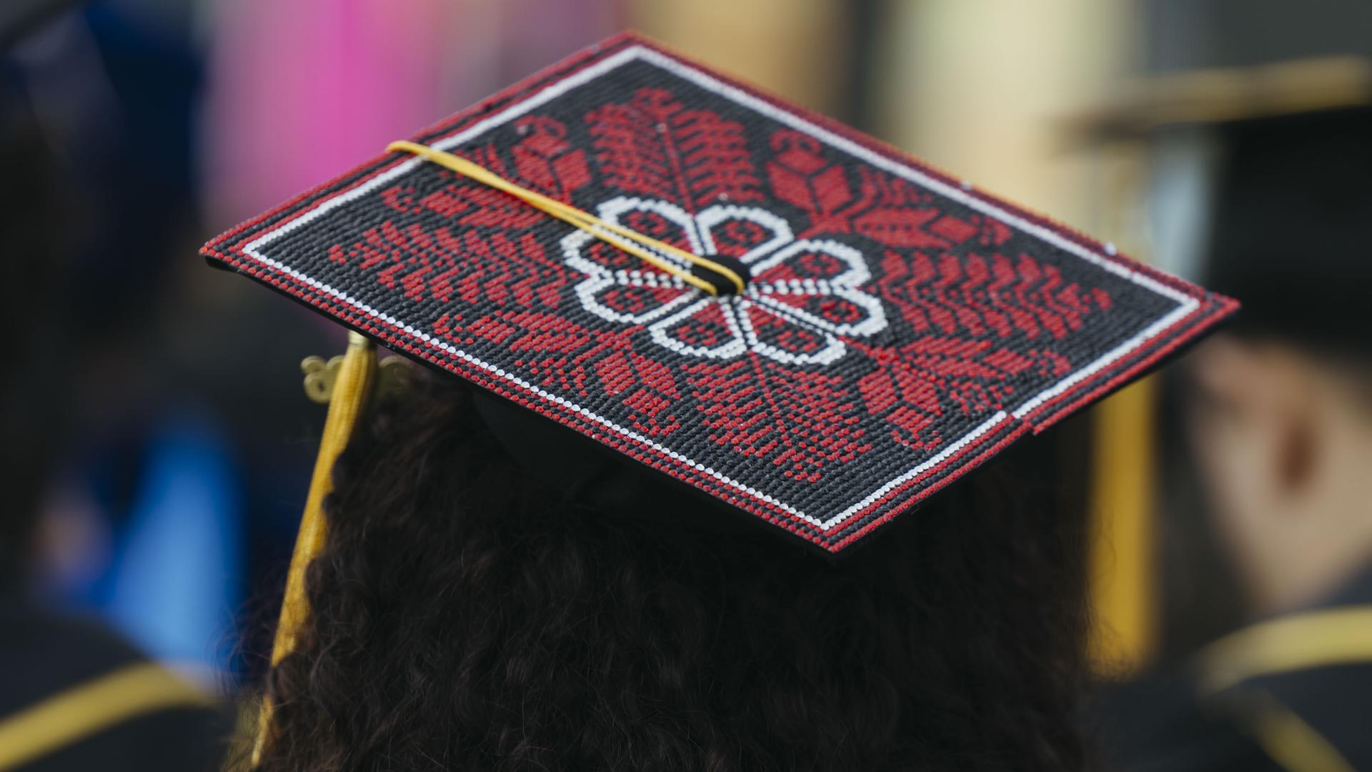 Graduation cap decorated with red embroidered floral pattern