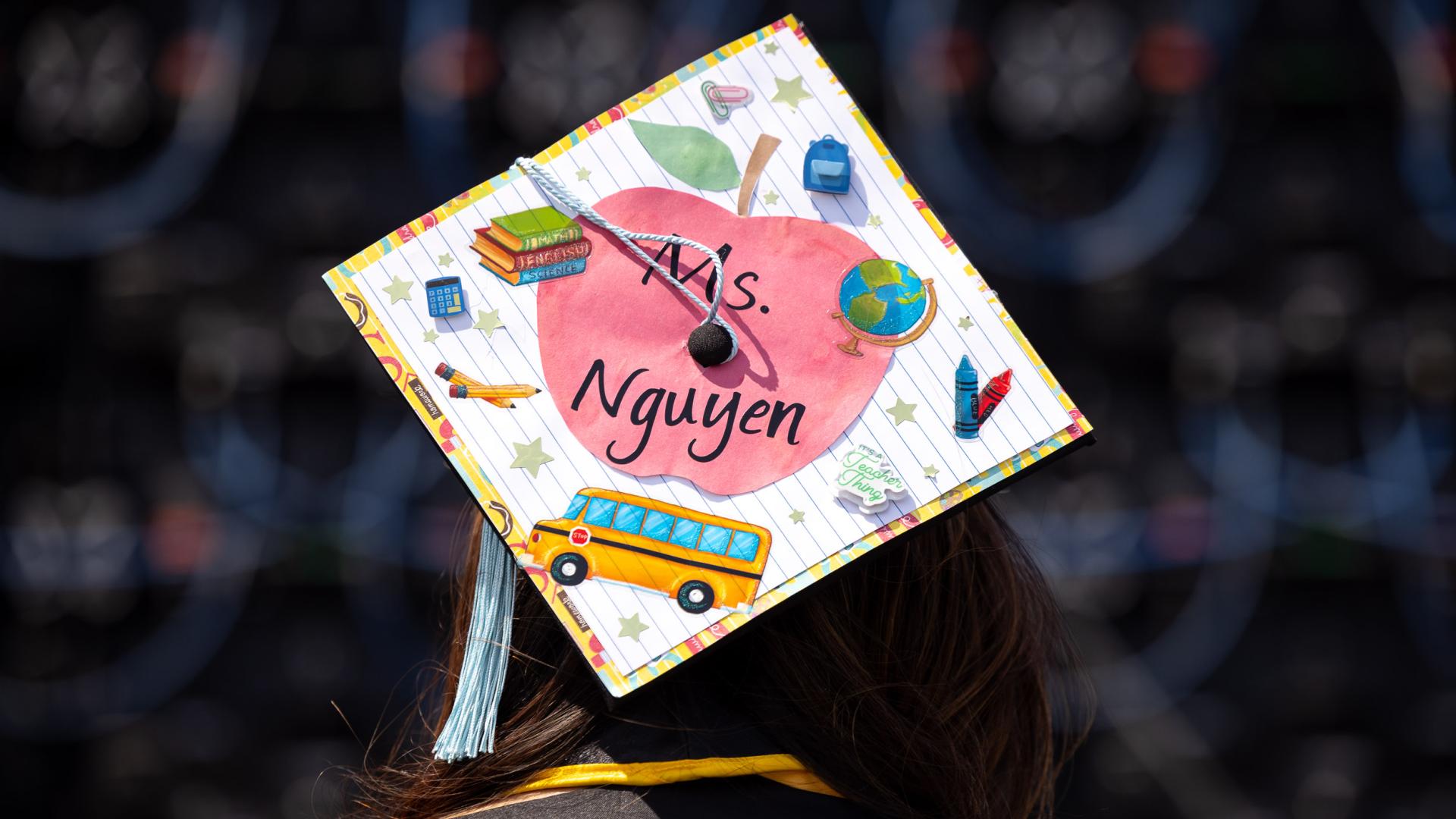 Graduation cap decorated with school-themed art reading "Ms. Nguyen"
