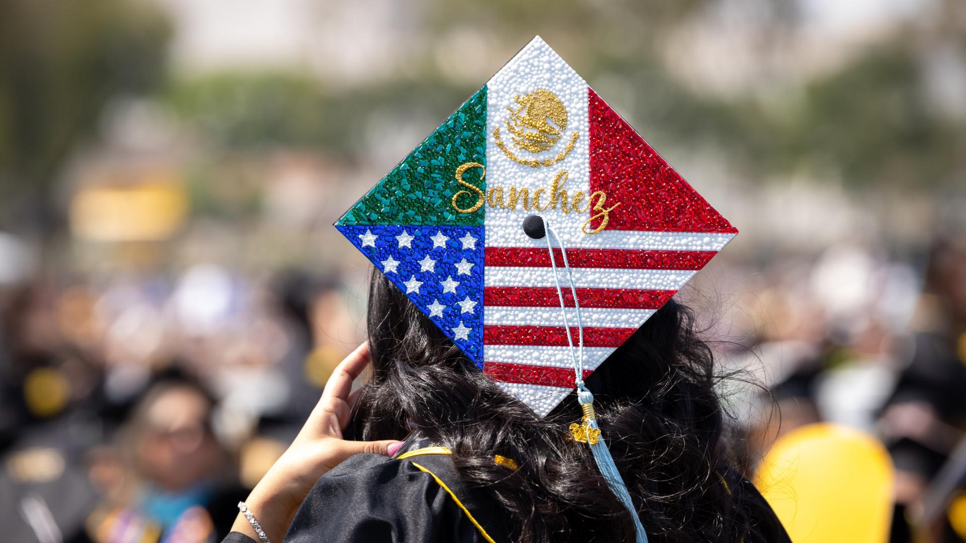 Graduation cap decorated with Mexican and American flag designs reading "Sanchez"