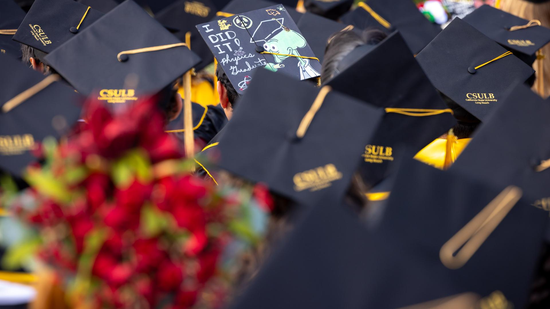 Graduation cap reading "I did it physics graduate" among sea of CSULB caps