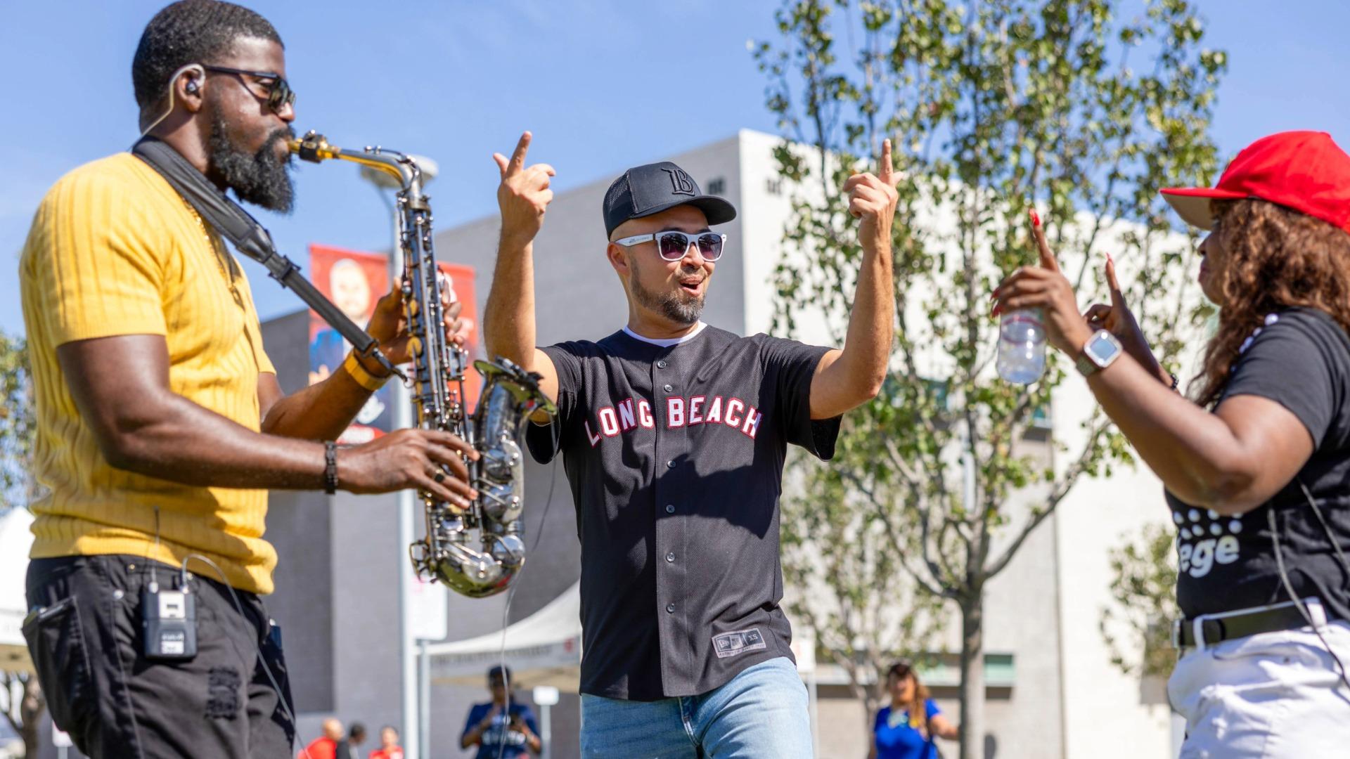 Mike Muñoz, center, encourages folks to enjoy the music at Long Beach City College