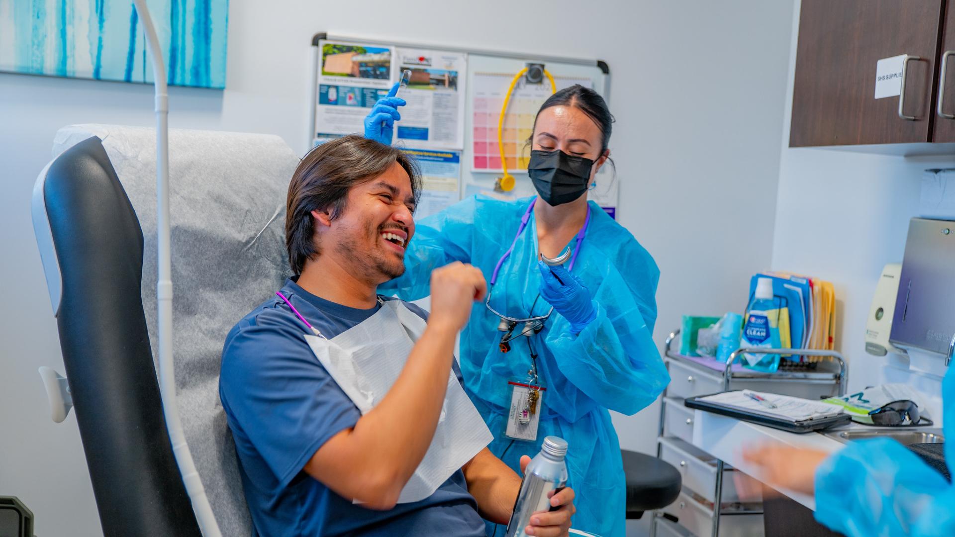 A student smiling with a dentist.