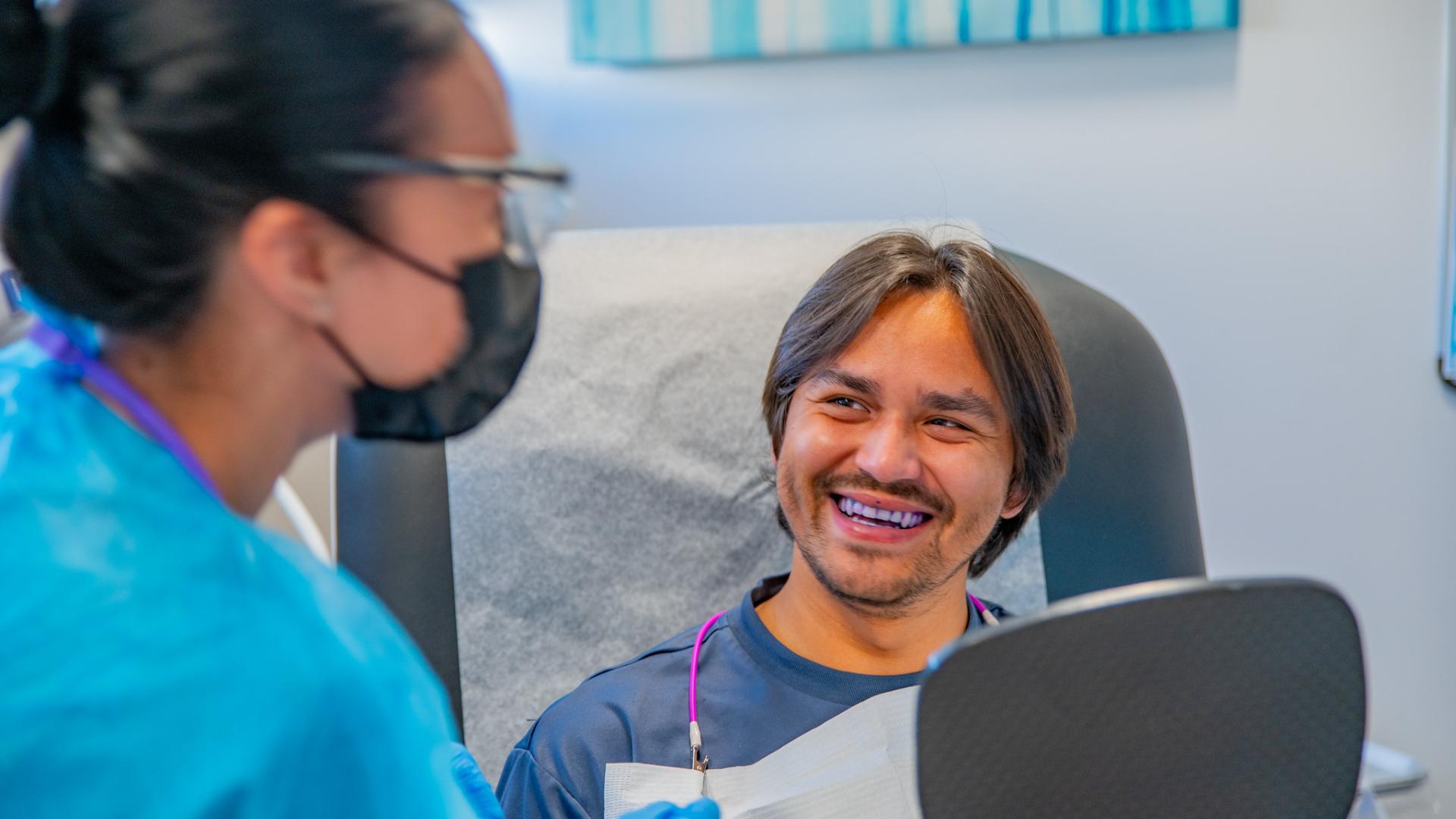 Student smiling at a dentist.