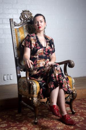 Oksana Nedavniaya sits in a chair.