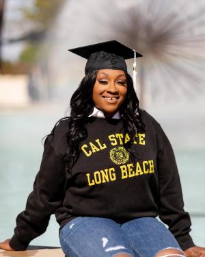 Graduate Janay Taylor in CSULB sweatshirt and cap