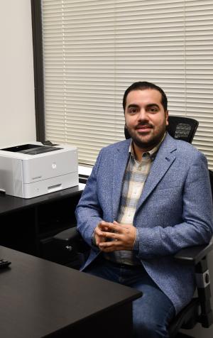 Amin Rezaei poses at desk