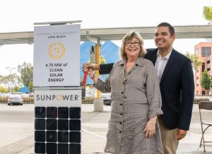 President Jane Close Conoley and Robert Garcia, then the mayor of Long Beach, by a display announcing new solar panels