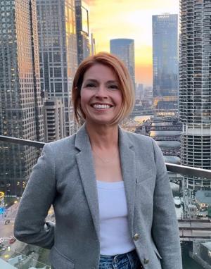 Faculty Advisor Dr. Kim Kelly smiling in front of city skyline