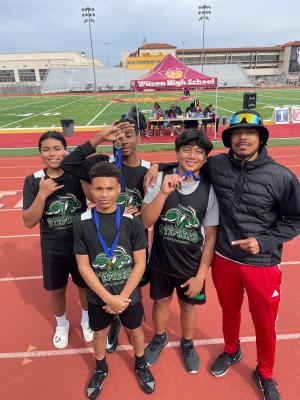 One of the Cooper twins with a group of young athletes posing with medals One of the Cooper twins with a group of young athletes posing with medals