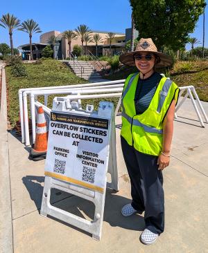 Parking employee standing next to sign