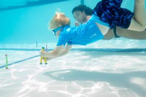 A child dives for a toy in a pool