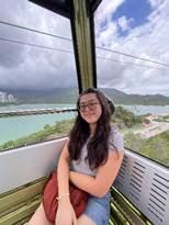 person riding in aerial tram with mountains in background
