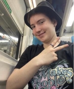 person in a hat making a peace sign