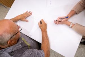 Two people writing on a paper