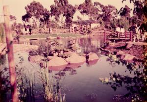 Old photo of the garden with people walking around the Koi pond.