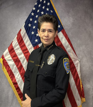 Chief Almaguer headshot in front of American flag.