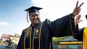 commencement-coe-hero4.jpg A smiling College of Engineering graduate flashes a piece si