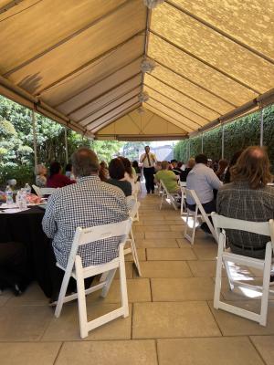 content_academic-senate-jg6.jpeg A large group of people are sitting at chairs and tables und
