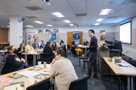 A room of training participants listening to a presentation from a representative from Institute for the Future. 