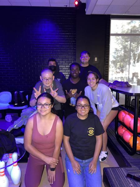 Students in Think Beach pose for a group photo at a bowling alley.