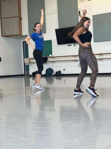 Two dancers perform in a dance studio.