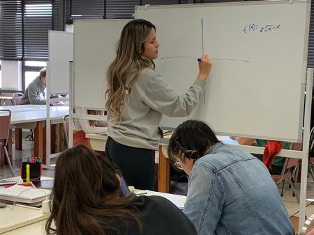 student writing on whiteboard