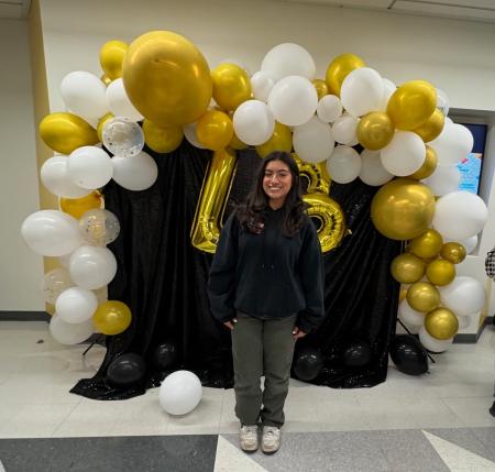 Marissa Moreno poses in front of a balloon arch.