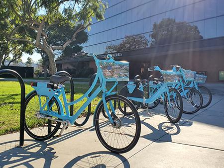 Blue bike share bikes in front of the College of Business