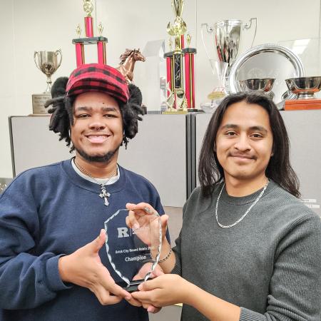 Forensics team duo Curtis Ortega, left, and Daniel Medina smile while holding a "Brick City Round Robin 2023 Champion" trophy, with trophies displayed in the background. Forensics team duo Curtis Ortega, left, and Daniel Medina smile while holding a "Brick City Round Robin 2023 Champion" trophy, with trophies displayed in the background.