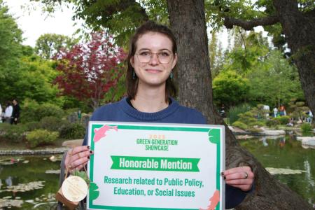 Student holding sign for honorable mention in the public policy, education, or social justice category