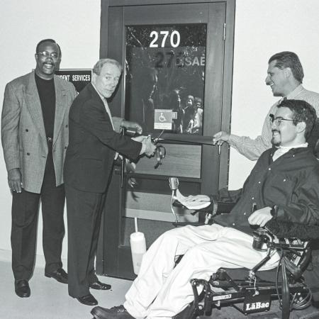 Robert "Bob" Maxson at CSULB Robert Maxson opens a door with others nearby, including a man in a wheelchair