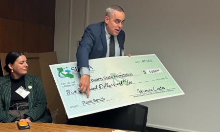 Scott Turner presents a decorative $5,000 check to students