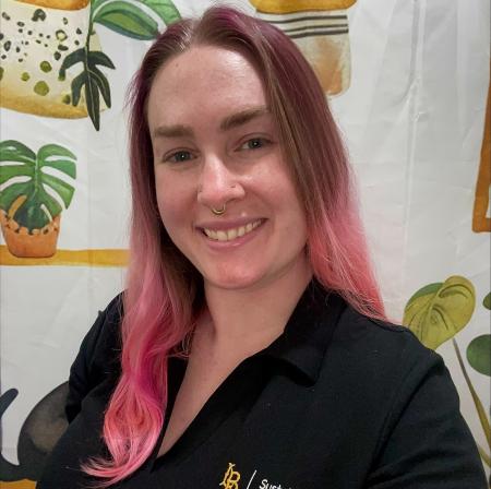 woman with pink hair wearing black polo