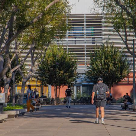 Students walk and sit in front of university building.