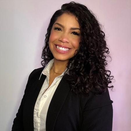 Portrait of a smiling person wearing professional attire.