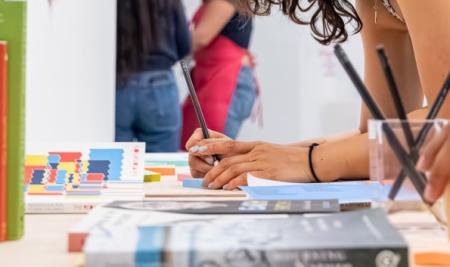 a hand writing on a piece of blue paper