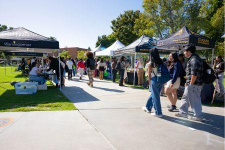 Students walking by booths on campus.