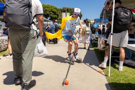 A student playing street hockey on campus.