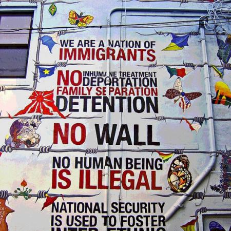 Artwork on the wall of a building relating to immigration