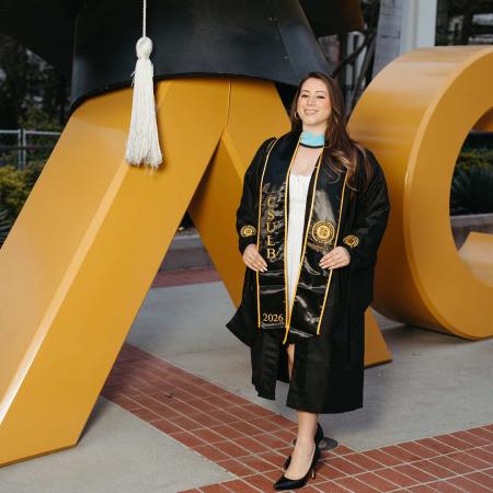 Yoli Montes '26 stands in front of the Go Beach sign