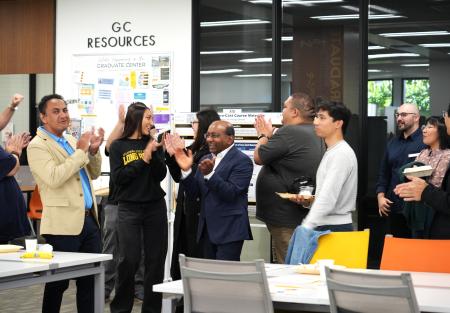 a group of students and staff clap their hands in celebration