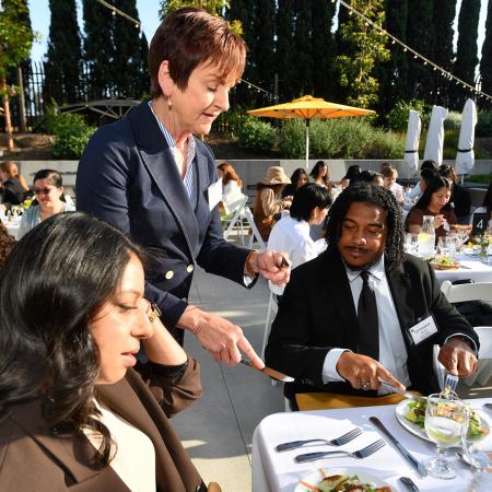 Diane Lee '83 helps Christopher Ferrera '26 on proper dining etiquette