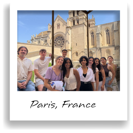 A group of people pose together in front of a gothic cathedral