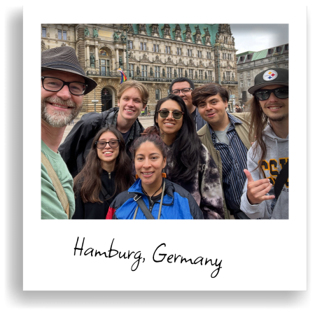 A group of people pose together for a selfie in front of a historic building