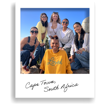 group of people pose together outdoors on a rocky hillside
