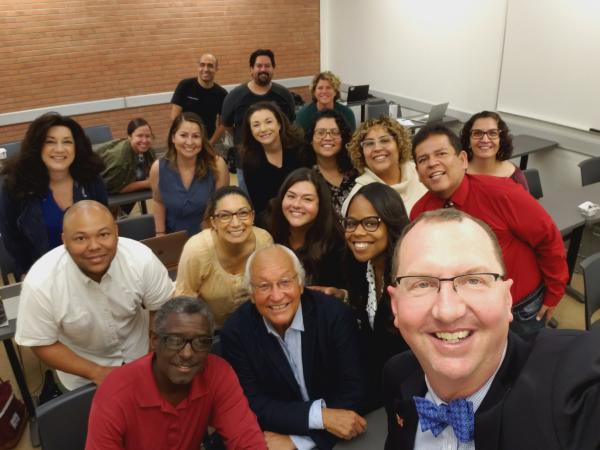 Dr. Bill Vega (middle, front row) poses with members of Cal State Long Beach’s Ed.D. cohort nicknamed Lucky 13 that graduated in May 2022. The selfie is being taken by a guest lecturer, Dr. Greg Schulz, superintendent-president of Citrus College.
